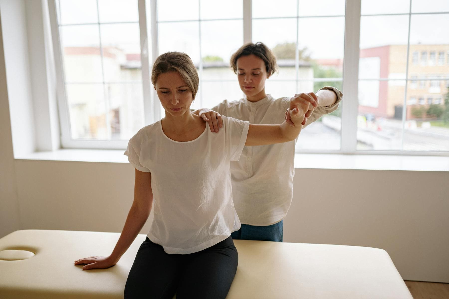 Physical therapist guiding arm mobility exercise